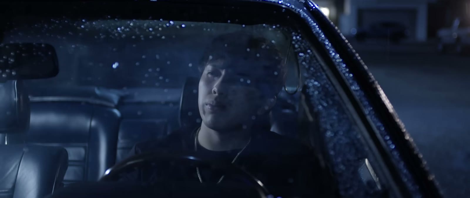 Alonso Ortiz dentro de un auto bajo la lluvia